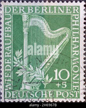 GERMANIA, Berlino - CIRCA 1950: Un francobollo dalla Germania, Berlino mostrando un arpa e il testo: Per la ricostruzione della Filarmonica di Berlino Foto Stock