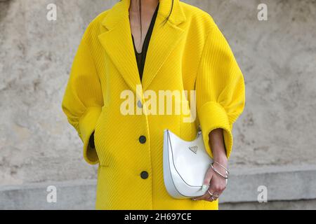 Milano, Italia - 24 settembre 2021: Vestito Street style, donna alla moda che indossa un vestito Prada giallo, borsa bianca a Milano. Foto Stock