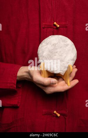 Uomo bianco che tiene la torta di tè in pu erh in camicia rossa Foto Stock