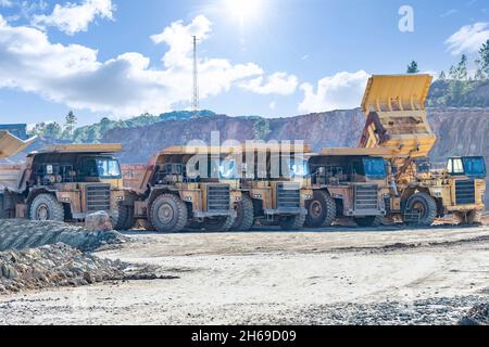 Camion e macchinari minerari a Corta Atalaya miniera aperta buca. Scavi profondi di pirite ed estrazione di minerali di cooper e oro in comune di Foto Stock