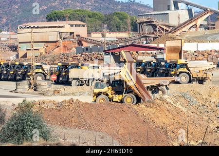 Camion e macchinari minerari a Corta Atalaya miniera aperta buca. Scavi profondi di pirite ed estrazione di minerali di cooper e oro in comune di Foto Stock