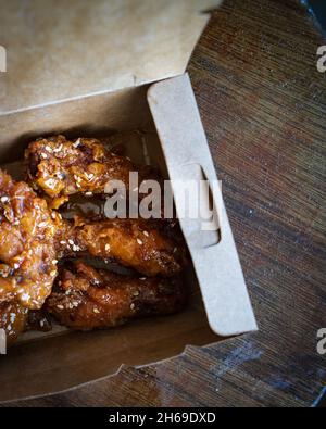 Ali di pollo fritto coreano e drummets in una scatola da portare via. Ricetta tradizionale asiatica. Foto Stock