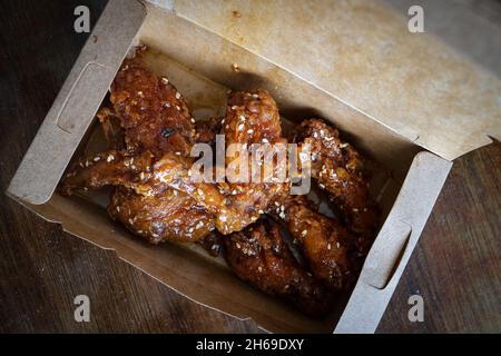 Ali di pollo fritto coreano e drummets in una scatola da portare via. Ricetta tradizionale asiatica. Foto Stock