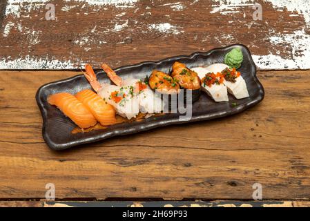 Vassoio di sushi assortiti di nigiri e gunkan di salmone norvegese, nigiri di pesce farfalla con uova di masago, wasabi, gamberi cotti con riso immerso in vineg giapponese Foto Stock