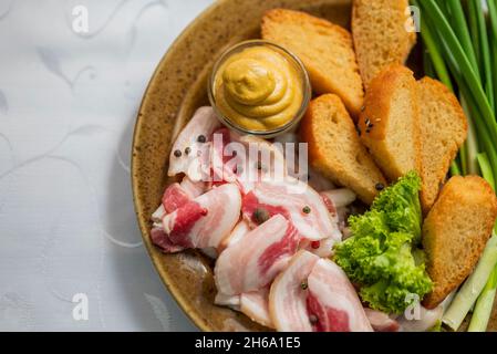 Cucina Ucraina. Piatto con pancetta a pezzi Salo con cipolle verdi e senape con pane Foto Stock