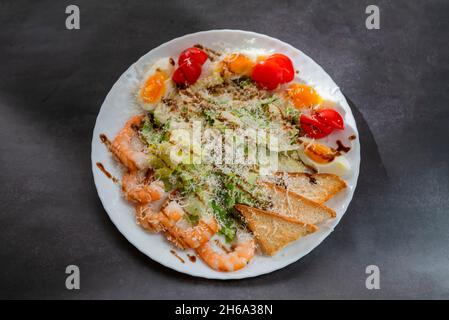 Insalata Caesar con lattuga di gamberi e pomodori ciliegini Foto Stock