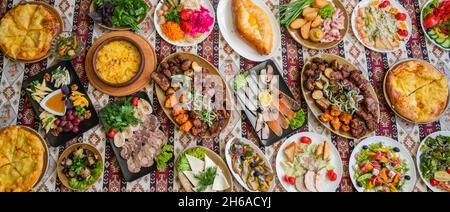 Panorama Georgiano e azerbaigiano cucina nazionale piatti suluguni cotto khachapuri, funghi e verdure ed erbe con un piatto di caffè assortiti Foto Stock