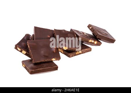 pezzi spezzati di cioccolato fondente con noci in un mucchio isolato su sfondo bianco. Foto di alta qualità Foto Stock