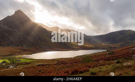 Sole che si infrangono attraverso le nuvole sopra la valle di Ogwen in Galles in un giorno d'autunno Foto Stock