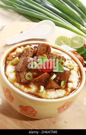 Una vista dall'alto del porridge indonesiano di riso con fette di carne Foto Stock