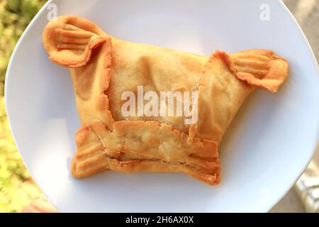 Gustosa carne o frutti di mare ripieni di salato Cileno o Empanadas su piatto bianco Foto Stock