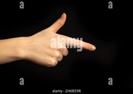 La mano punta a qualcosa. Donna mano gesto, segno di puntamento, gesto guardare questo, State attenti. Sfondo nero Foto Stock