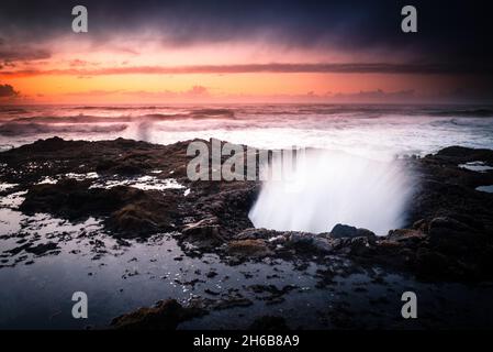 Tramonto sopra il pozzo di Thor sulla costa dell'Oregon Foto Stock