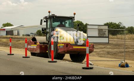 Da Mackay a Townsville Bruce Highway, Queensland, Australia - Novembre 2021: Macchina pesante a rulli che lavora sulla costruzione di strade con conducente visibile in ca Foto Stock