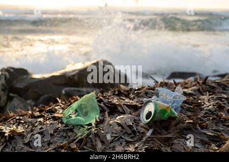 Bottiglia di plastica e rifiuti di alluminio sulla costa oceanica, inquinamento da detriti ambientali Foto Stock