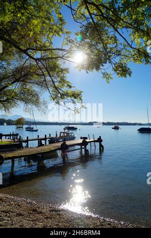 Un vecchio molo di legno sull'isola Frauenchiemsee sul lago Chiemsee in Baviera in una giornata di sole a maggio (Germania) Foto Stock