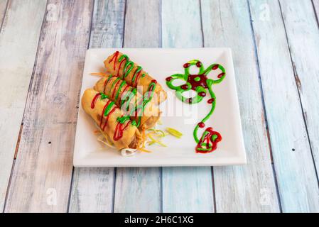 involtini croccanti ripieni di formaggio con salsa di pomodoro e verdure fritte in olio d'oliva Foto Stock