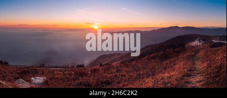 Vista panoramica del rifugio Vittorio Veneto sulla cima del monte Pizzoc (provincia di Treviso, veneto, italia) contro le nuvole al tramonto in autunno Foto Stock