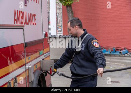 NEW YORK, NY – 14 NOVEMBRE: Un tecnico medico di emergenza FDNY alimenta un'ambulanza in una stazione di benzina mobile il 14 novembre 2021 a New York City. Stando in piedi di fronte ad una stazione di benzina Mobil sulla 8th Avenue nel West Village, i prezzi iniziano a $4.33 un gallone per un gallone di 87 ottani di benzina, il leader della maggioranza del Senato degli Stati Uniti il senatore Chuck Schumer (D-NY) dice che i conducenti di New York hanno disperatamente bisogno del rilievo dall'aumento dei prezzi del carburante. Il senatore Schumer spera che sfruttare la Riserva strategica del petrolio della nazione contribuirebbe a ridurre i costi del carburante per un po'. Foto Stock