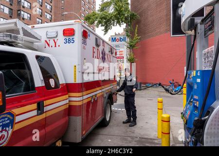 NEW YORK, NY – 14 NOVEMBRE: Un tecnico medico di emergenza FDNY alimenta un'ambulanza in una stazione di benzina mobile il 14 novembre 2021 a New York City. Stando in piedi di fronte ad una stazione di benzina Mobil sulla 8th Avenue nel West Village, i prezzi iniziano a $4.33 un gallone per un gallone di 87 ottani di benzina, il leader della maggioranza del Senato degli Stati Uniti il senatore Chuck Schumer (D-NY) dice che i conducenti di New York hanno disperatamente bisogno del rilievo dall'aumento dei prezzi del carburante. Il senatore Schumer spera che sfruttare la Riserva strategica del petrolio della nazione contribuirebbe a ridurre i costi del carburante per un po'. Foto Stock