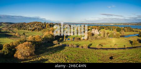 Panorama sul castello e parco di Powderham da un drone in colori autunnali, Exeter, Devon, Inghilterra, Europa Foto Stock