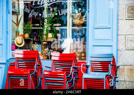 Cartolina l'esterno grazioso di un bar e caffè a Auray, Bretagna, Francia. Sedie rosse contro persiane blu. Stile di vita francese. Foto Stock