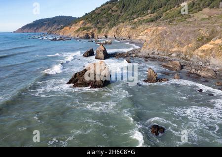 Il sereno Oceano Pacifico si lava sulla costa frastagliata della California settentrionale, non lontano a nord di Fort Bragg nella contea di Mendocino. Foto Stock