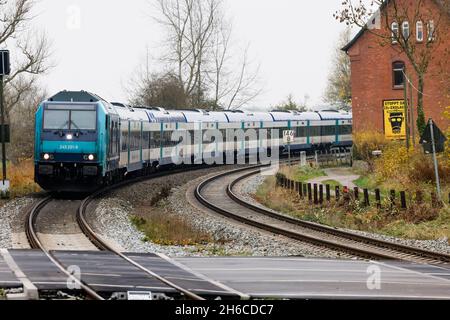 Friedrichstadt, Germania. 14 novembre 2021. Un treno regionale espresso percorre la linea Marschbahn attraverso Friedrichstadt in direzione Westerland. Il 1° novembre 2021, l'espansione della capacità della Marschbahn, finanziata dallo Stato di Schleswig-Holstein e Deutsche Bahn, è giunta al termine. L'obiettivo era quello di fornire più seggi. Credit: Frank Molter/dpa/Alamy Live News Foto Stock