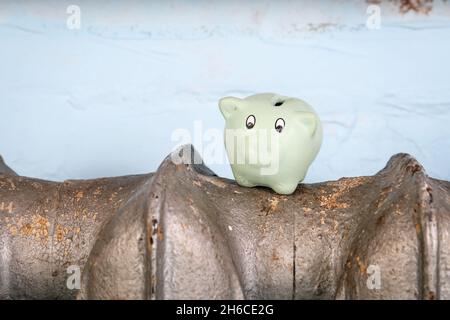 Piggy Bank su radiatori in ghisa, riscaldatore. Spese di riscaldamento della famiglia. Foto Stock