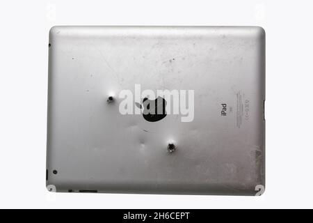 Vista posteriore del vecchio iPad argento con fori per proiettile isolati su bianco. Russia, 22.03.2020 Foto Stock