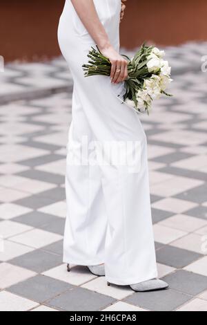 Giovane donna con bel bouquet su sfondo chiaro Foto Stock