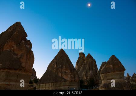 Camini fata. Peri bacalari o camini fairy all'alba con la luna sul cielo Foto Stock