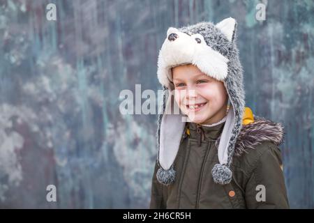 Bambino in un cappello lupo su sfondo grigio, all'aperto. Foto di alta  qualità Foto stock - Alamy