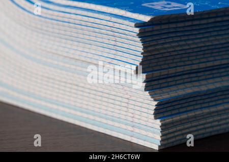 Stack di notebook. Ritorno a scuola. Una confezione di taccuini blu scuola sul tavolo in una classe. Pila di libri di esercizi. Pacchetti matematici a scacchi Foto Stock