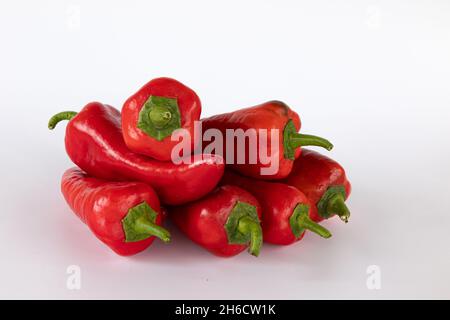 mucchio di peperoni freschi isolati su sfondo bianco, verdure crude, raccolto nuovo di peperoni rossi, vista laterale Foto Stock