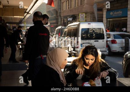 Istanbul, Turchia-12 novembre 2021: Le donne mangiano il famoso dessert turco ''baklava'' in un ristorante nel distretto di Karakoy della città. Foto Stock