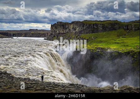 Hiker in piedi vicino alla cascata Dettifoss in Islanda Foto Stock