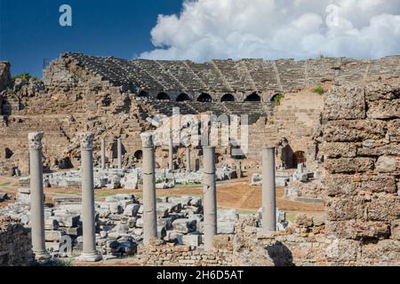 Vista esterna del teatro antico laterale, agora e piazza colonnata. Cielo nuvoloso blu. Rovine selettive del fuoco. Foto Stock