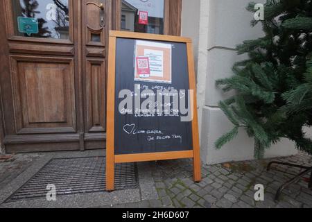 Potsdam, Germania. 15 Nov 2021. Un cartello che indica la regola 2G è visibile sulla porta d'ingresso di una caffetteria. A Brandeburgo entrano in vigore le più severe norme Corona. La regola del 2G con accesso solo per le persone vaccinate e ricoverate diventa obbligatoria per alcune aree, più un requisito di maschera nelle scuole primarie. Credit: Jörg Carstensen/dpa/Alamy Live News Foto Stock