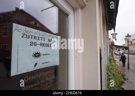 Potsdam, Germania. 15 Nov 2021. Un cartello che indica la regola 2G è visibile sulla porta d'ingresso di un ristorante. A Brandeburgo entrano in vigore le più severe norme Corona. La regola del 2G con accesso solo per le persone vaccinate e ricoverate diventa obbligatoria per alcune aree, più un requisito di maschera nelle scuole primarie. Credit: Jörg Carstensen/dpa/Alamy Live News Foto Stock