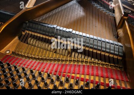 Vista a martello e smorzatore sulle corde all'interno di un vecchio pianoforte grande, parte della meccanica nello strumento musicale acustico, fuoco selezionato, stretto Foto Stock