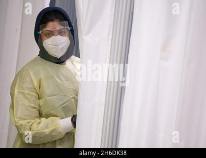 15 novembre 2021, Hessen, Francoforte sul meno: Il dipendente di un centro temporaneo di test corona attende i clienti. Nel frattempo, l'incidenza della corona continua ad aumentare a livello nazionale. Foto: Boris Roessler/dpa Foto Stock