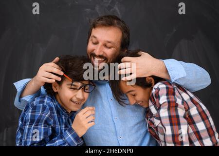 felice padre abbracciare figli momenti indimenticabili di gioia di famiglia in gara mista medio orientale famiglia araba Foto Stock