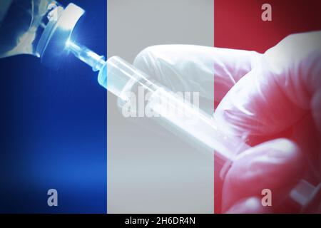 Siringa con bandiera francese come sfondo, concetto di 3a dose di vaccinazione in Francia Foto Stock