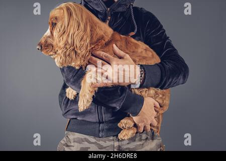 Uomo che tiene il cane spaniel cocker in braccio Foto Stock