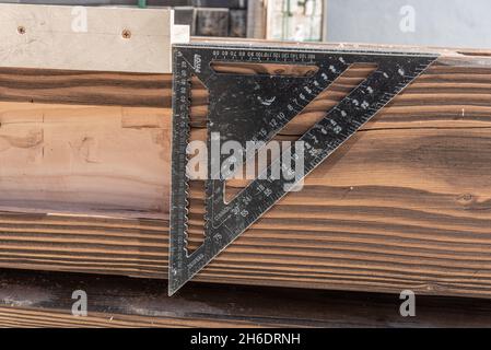 Misura, pianta e disegno di carpenteria su fondo grezzo di legno. Righello triangolare e misurazione dell'angolo Foto Stock