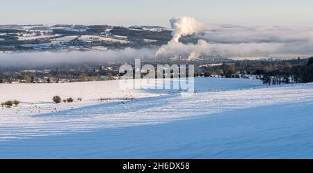 Città di Hexham e nebbia riempì la valle di Tyne alla luce del mattino con campi coperti di neve, pecore in primo piano e colline coperte di neve sullo sfondo. Foto Stock