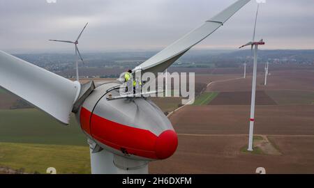 Bernsdorf, Germania. 15 Nov 2021. Due tecnici della Sabowind GmbH gestiscono una turbina eolica Enercon E92. Lo stesso giorno, la campagna 'Energieland Sachsen. Rinnovare insieme". La campagna intende utilizzare esempi concreti per dimostrare perché l'economia della Sassonia ha bisogno di energia verde e come le imprese e i cittadini sassoni possono trarre vantaggio dalla transizione energetica. (Vista aerea con drone) Credit: Jan Woitas/dpa-Zentralbild/dpa/Alamy Live News Foto Stock