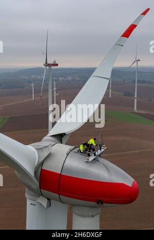 Bernsdorf, Germania. 15 Nov 2021. Due tecnici della Sabowind GmbH gestiscono una turbina eolica Enercon E92. Lo stesso giorno, la campagna 'Energieland Sachsen. Rinnovare insieme". La campagna intende utilizzare esempi concreti per dimostrare perché l'economia della Sassonia ha bisogno di energia verde e come le imprese e i cittadini sassoni possono trarre vantaggio dalla transizione energetica. (Vista aerea con drone) Credit: Jan Woitas/dpa-Zentralbild/dpa/Alamy Live News Foto Stock