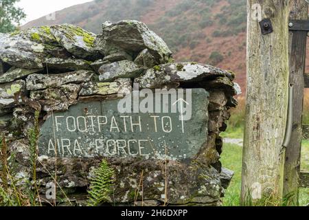 Cartello in ardesia che indica la direzione del sentiero per la cascata dell'Aira Force nel Lake District, Cumbria, Inghilterra, Regno Unito Foto Stock